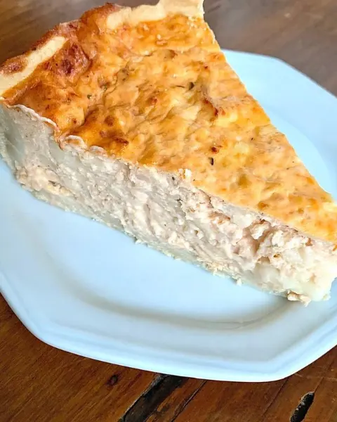 Fatia de quiche servida em prato branco